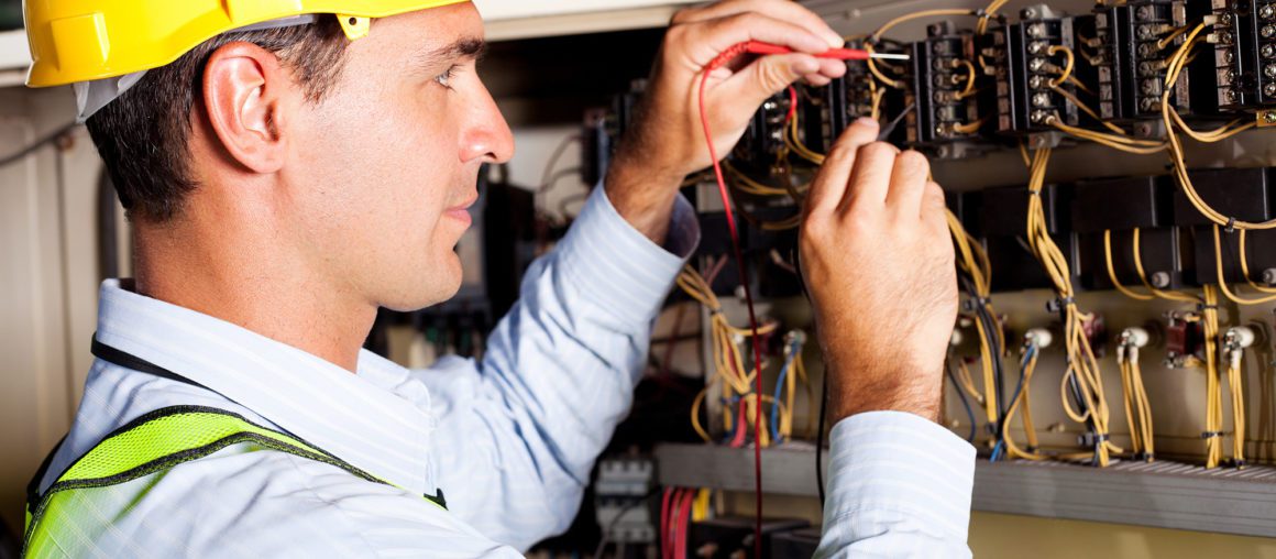 male electrician testing industrial machine